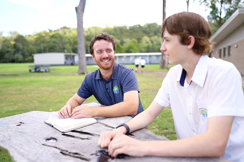 Wellbeing staff meeting with a student outside